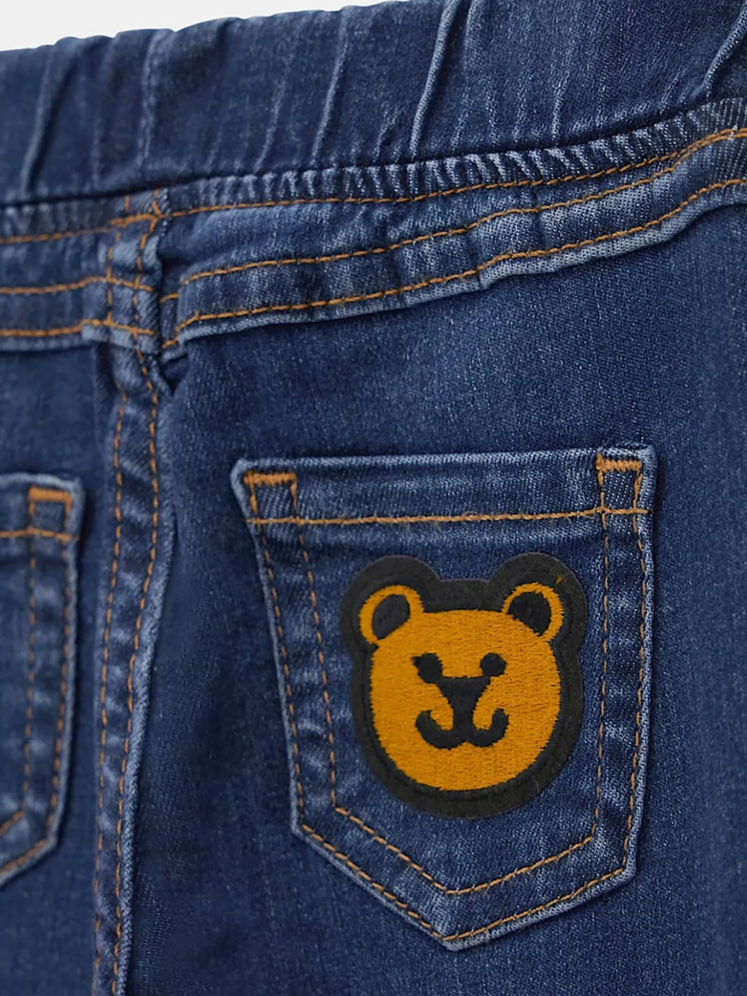 Jeans pull on con orsetto sul retro denim scuro